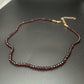 Sky blue faceted glass bead choker necklace laid flat in a loop