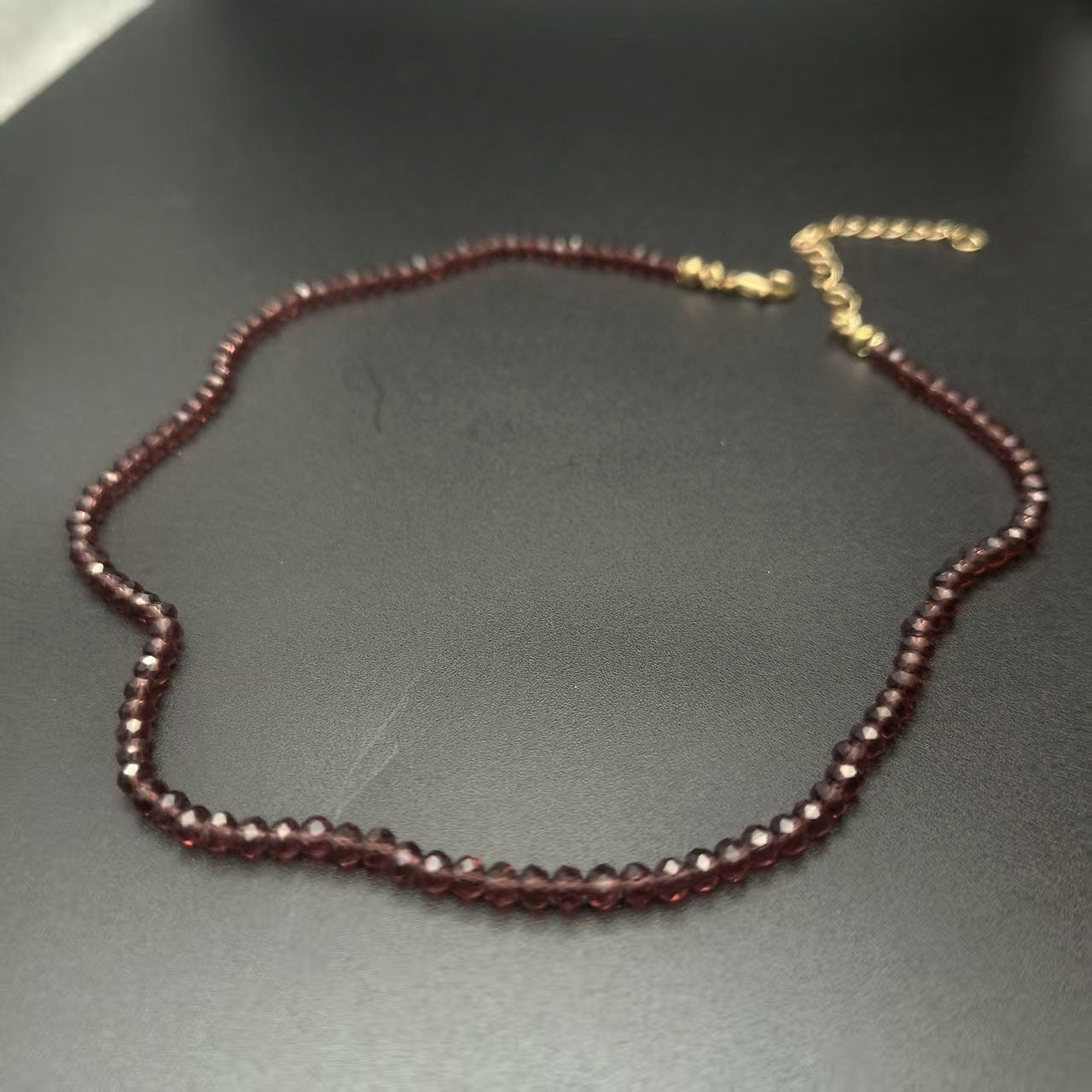 Sky blue faceted glass bead choker necklace laid flat in a loop