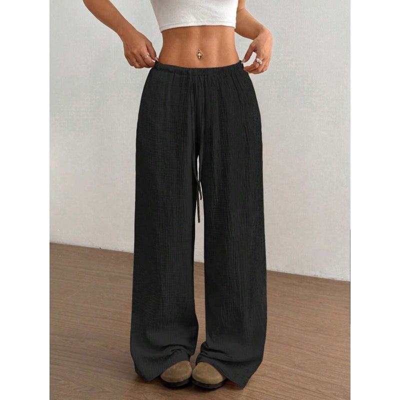 Close view of the elastic drawstring waistband on the wide leg cotton trousers