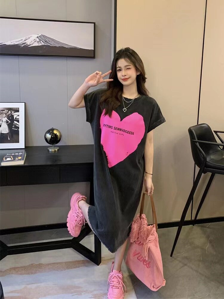 Washed grey T-shirt dress with pink heart print and small text, mid-calf length on model