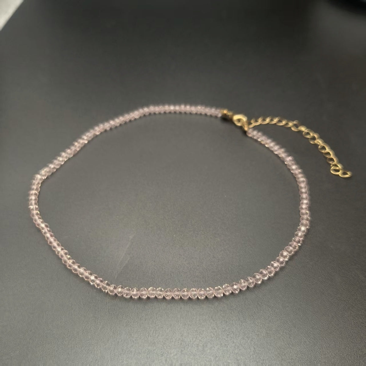 Brown faceted glass bead necklace with a gold tone extender chain