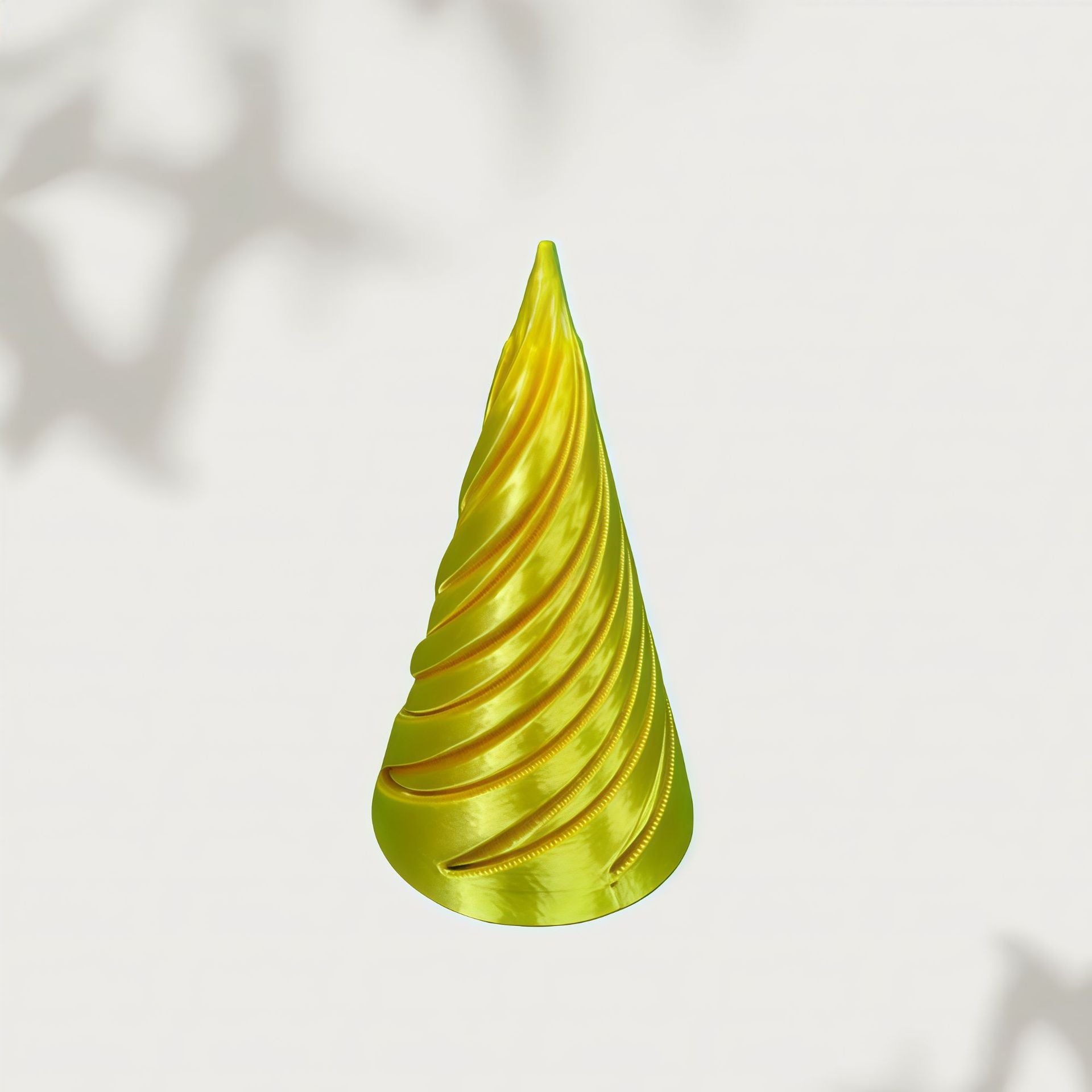 Chartreuse gradient spiral cone floating against a soft white backdrop with leaf shadows