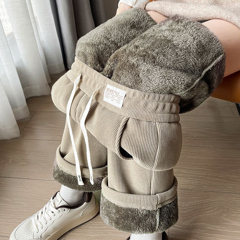 Oatmeal ribbed fleece lined pants with a drawstring waist, woven label and the plush lining visible at the waist
