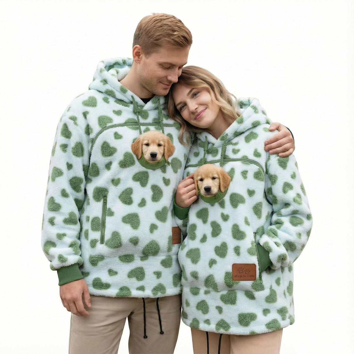 Couple in matching mint green heart print fleece hoodies with a puppy looking out of each chest pouch
