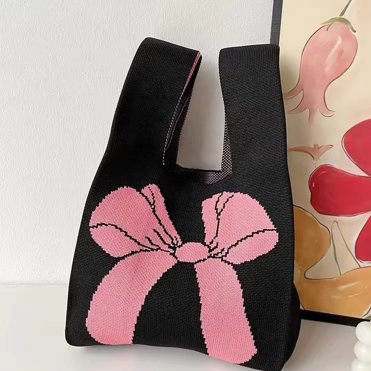 Soft knitted wrist handbag with a jacquard pattern and a built in loop handle
