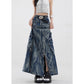 Close angle on the cargo flap pockets, D-ring straps and metal rivets of the washed denim maxi skirt