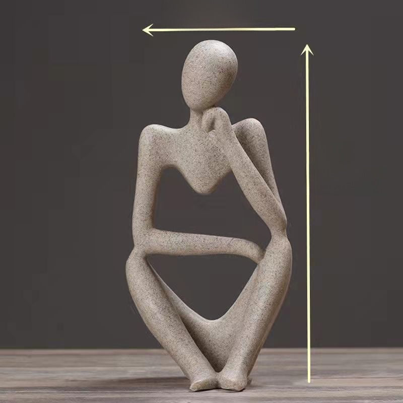 Speckled sandstone abstract resin meditator figurine posed in thought on a dark backdrop