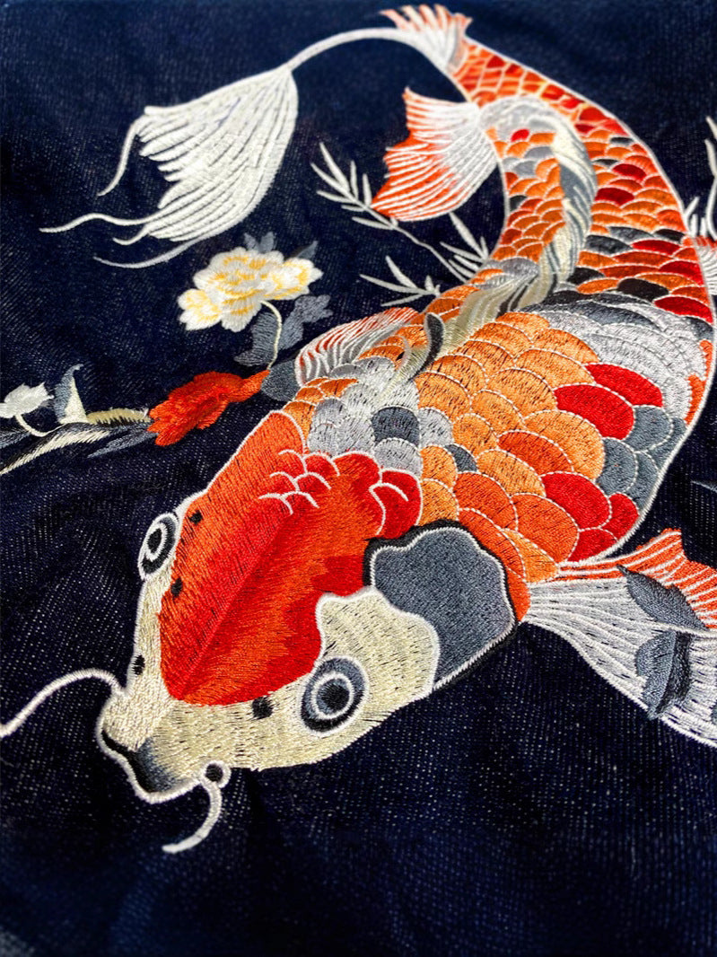 Close-up of cotton denim weave and hand-placed embroidery stitching