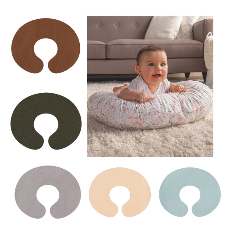 Five solid pillowcase colors, brown, dark olive, gray, peach and blue, beside a baby lying on a pillow near a sofa