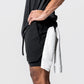 Man wearing the two in one training shorts in black, holding a towel after a workout