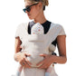 Beige cotton baby carrier with a padded head flap, worn on the front with cross-back straps