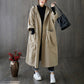 Woman wearing the loose hooded long coat layered over jeans and sneakers