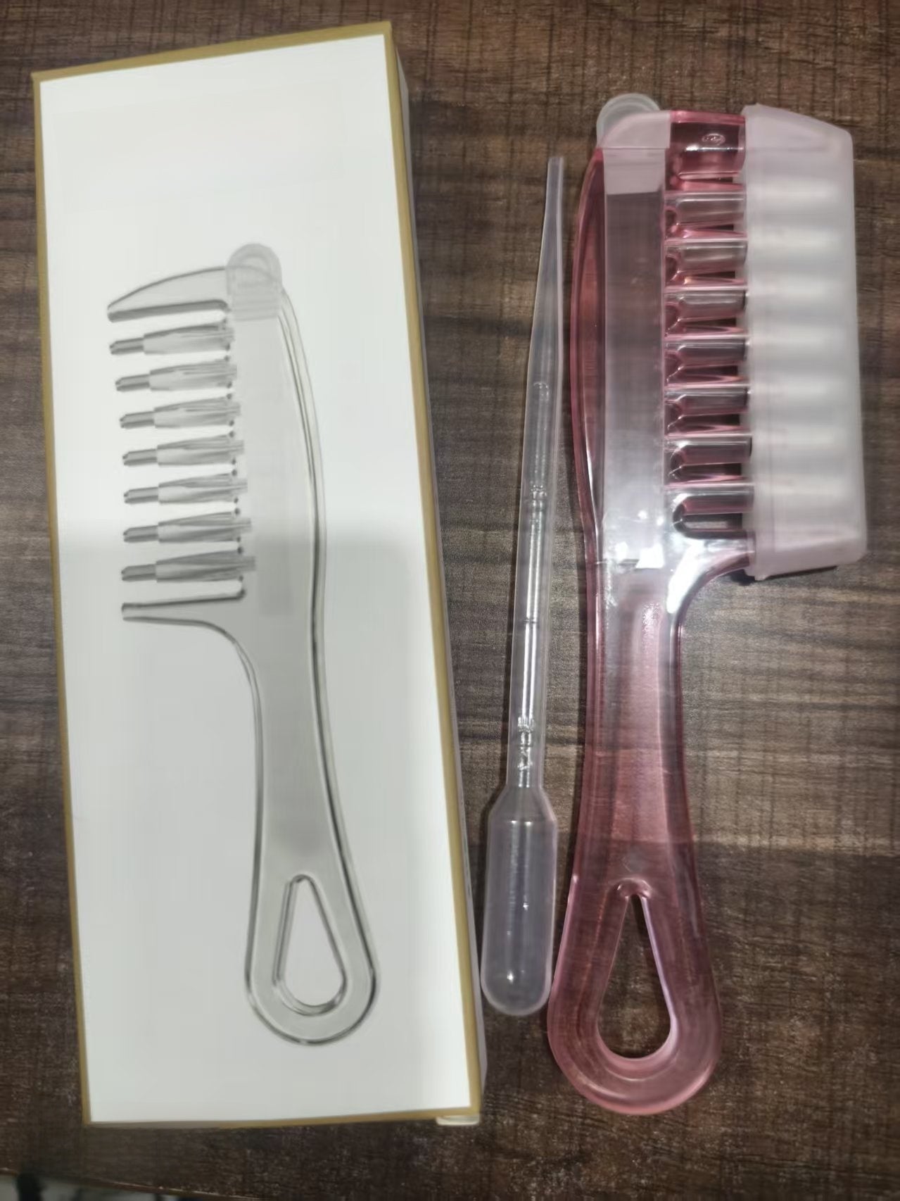 Clear liquid guide comb gliding along the part to deliver serum to the scalp