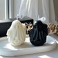 Orange pumpkin ghost scented candle with a lit wick