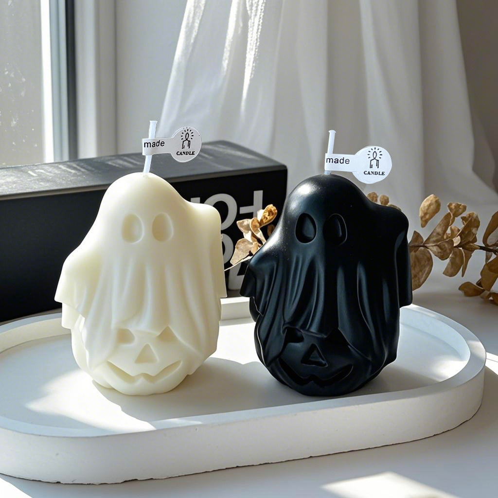 Orange pumpkin ghost scented candle with a lit wick
