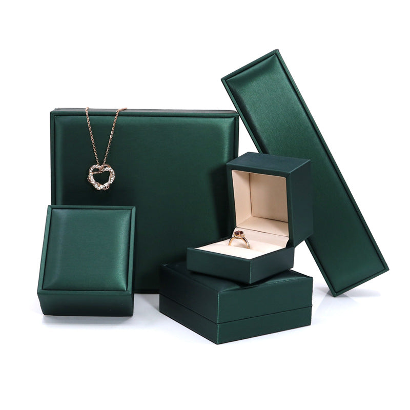 Malachite green jewelry boxes with a necklace on a large box and an open ring box
