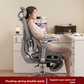 Person seated in the mesh task chair with the headrest set high and the footrest extended