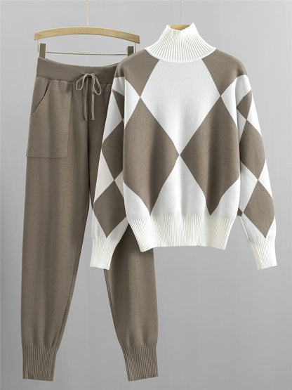 Khaki argyle knit sweater with white high neck and matching khaki jogger pants hanging side by side on a grey wall