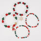 Flat lay of four mixed color bead stretch bracelets, one with a snowflake charm and one with a bell charm