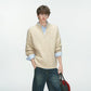 Cream half zip cable knit sweater with a stand collar over a light blue shirt on a male model, front view