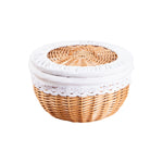 Round handwoven rattan basket with fabric covered lid and white lace trim lining on a white background