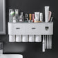 Wall mounted toothbrush holder with rinse cups and an automatic toothpaste dispenser