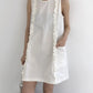 White ruffle trim sleeveless A-line dress with a front patch pocket, styled with boots