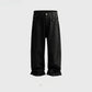Black waxed coated loose falling wide leg jeans shown flat on a plain pale studio background