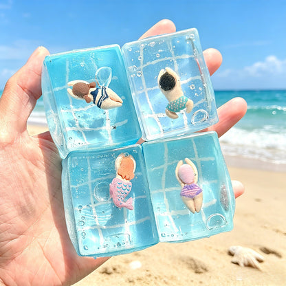 Clear TPR squishy sensory toys with tiny swimmers inside on a beach backdrop