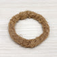 Ring of coconut fiber on a pale wooden surface, bowl base option photo