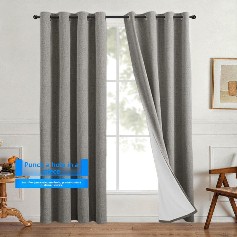 Linen look polyester blackout grommet curtain panel with white thermal backing styled over a floor to window drop