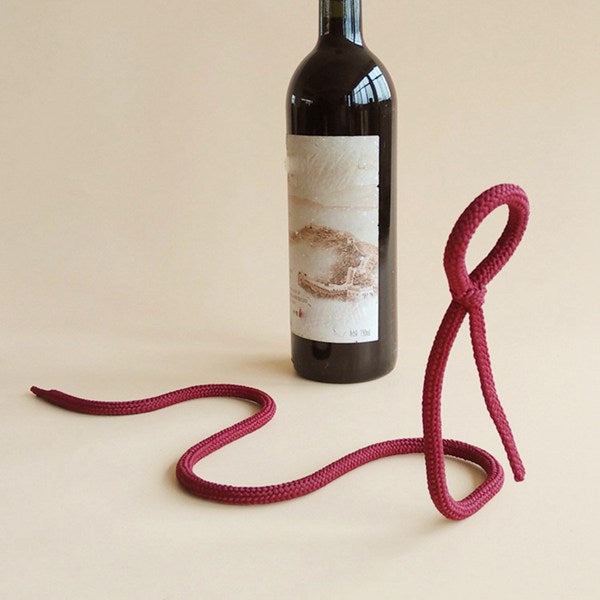 Burgundy rope holder curved like a snake beside an upright red wine bottle, burgundy color not offered
