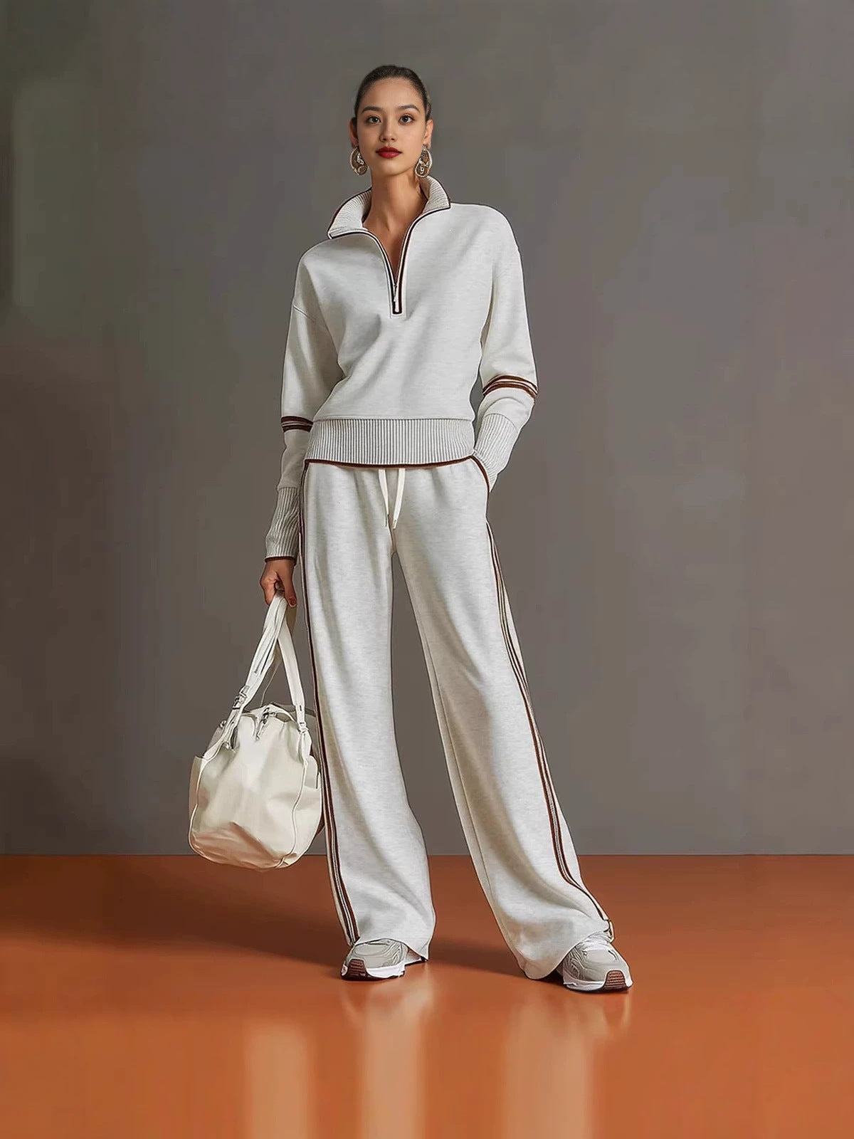 White half zip sweatshirt and wide leg pants set with brown piping, worn full length