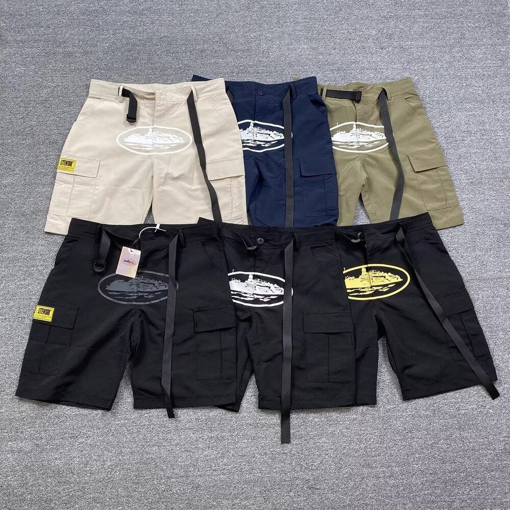 Retro cargo shorts laid out in several colorways with an oval island print on a grey studio floor