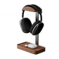 Walnut wood headphone stand on a slim black metal post cradling an over ear headset