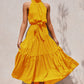 Yellow polka dot halter neck sleeveless tiered swing maxi dress worn by a model
