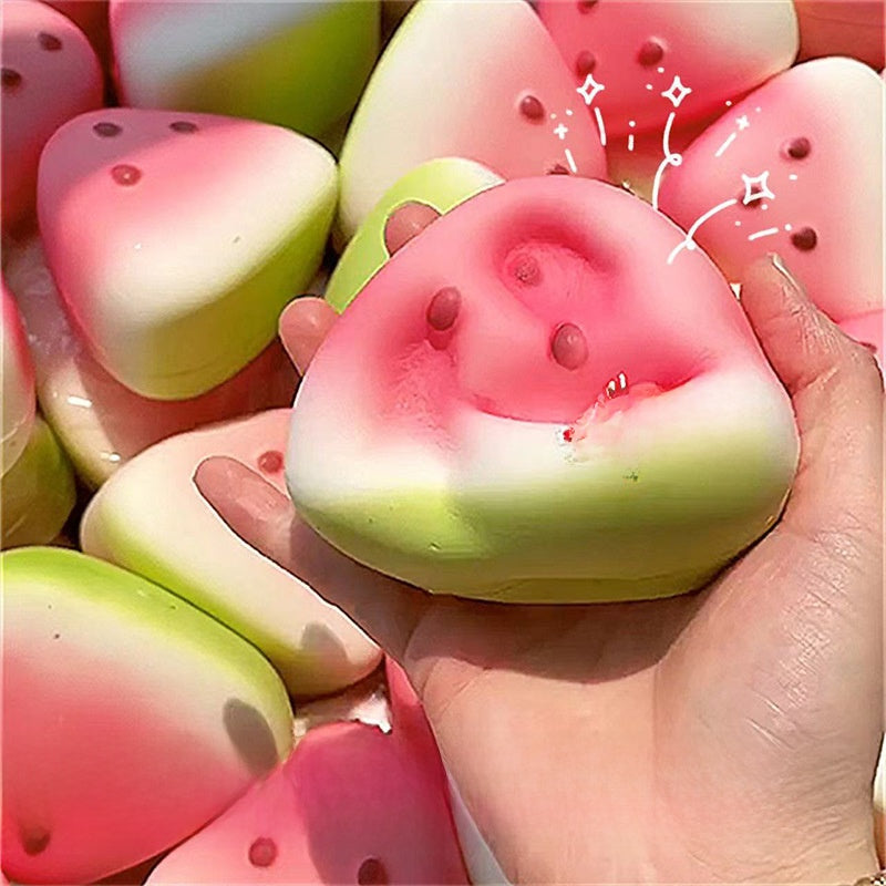 Strawberry shaped soft slow rebound squishy toy with a printed face on a plain background