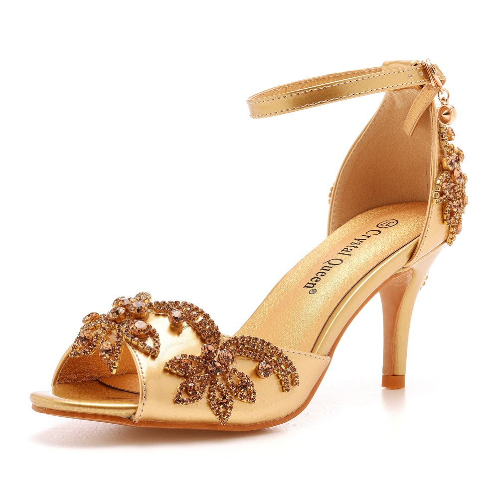 Single gold rhinestone stiletto sandal seen at an angle, buckled ankle strap and open toe