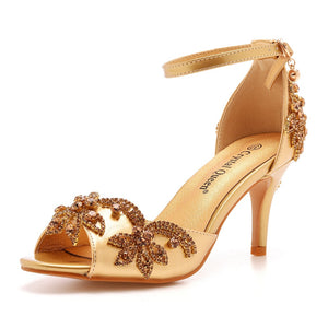 Single gold rhinestone stiletto sandal seen at an angle, buckled ankle strap and open toe