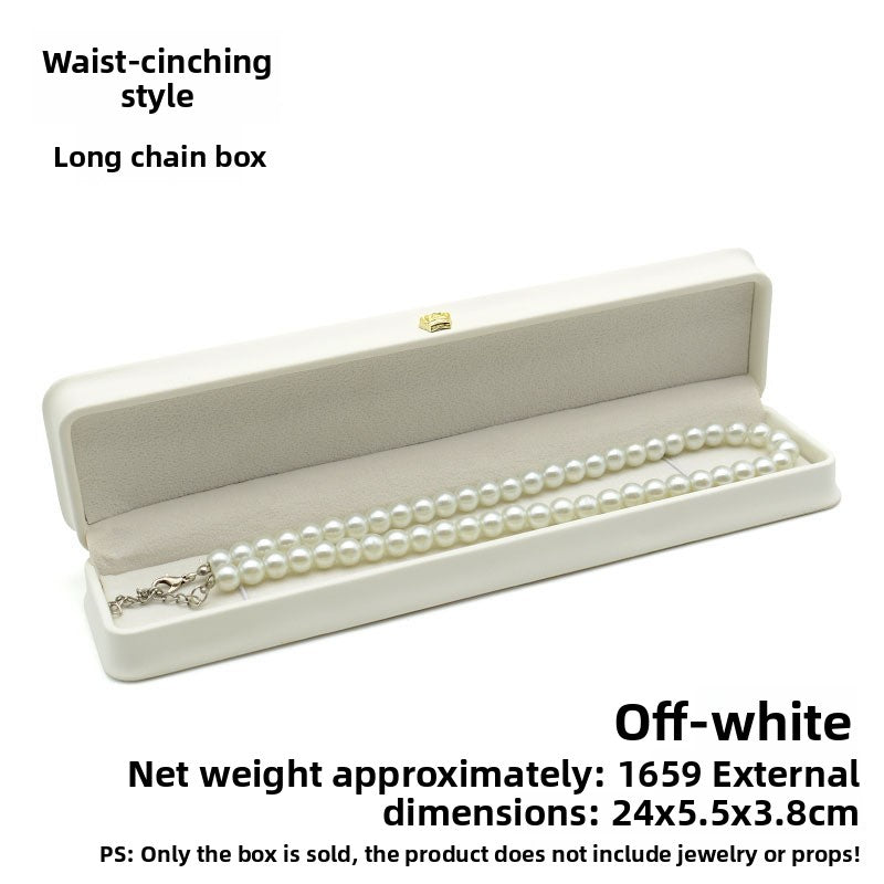 Open off white crown clasp necklace box with a pearl necklace on the grey padded lining