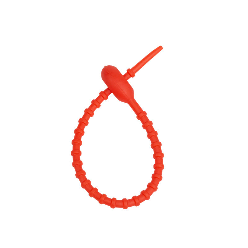 Soft silicone tadpole cable tie coiled into a loop to show the reusable cinch closure