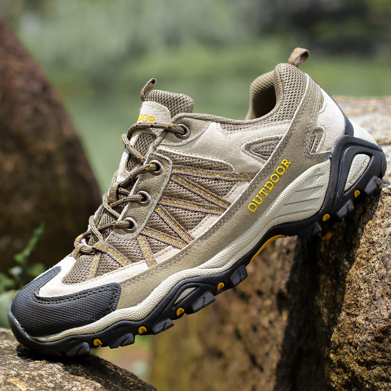Suede and mesh low cut hiking shoe with a deep lugged rubber outsole on a mossy rock