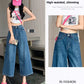 Retro blue wide-leg cropped jeans worn with a white tank and pink cap