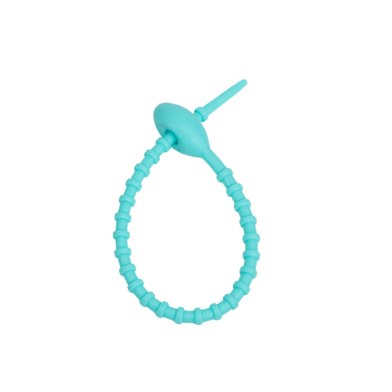 Tadpole silicone tie looped around a wrist to show how flexible the strap is