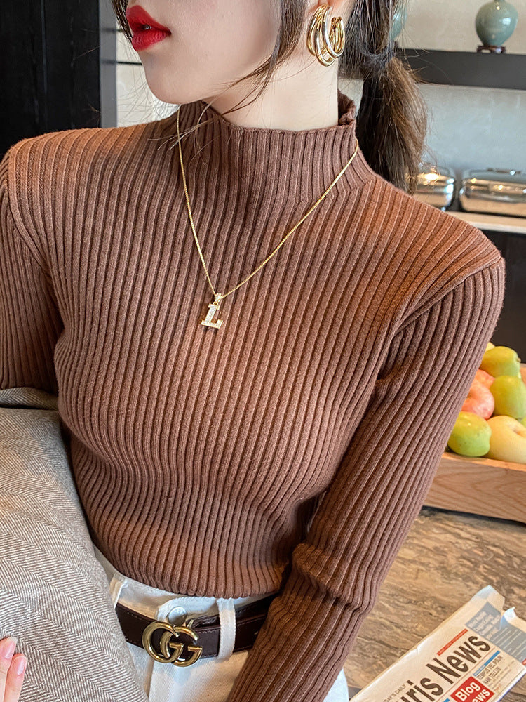 Woman wearing a slim ribbed semi high mock neck knit sweater as a fitted base layer