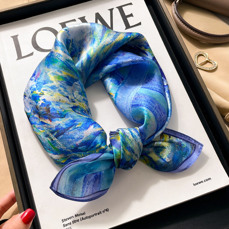 Blue abstract oil paint printed square scarf with a satin sheen and hemmed edges, shown displayed