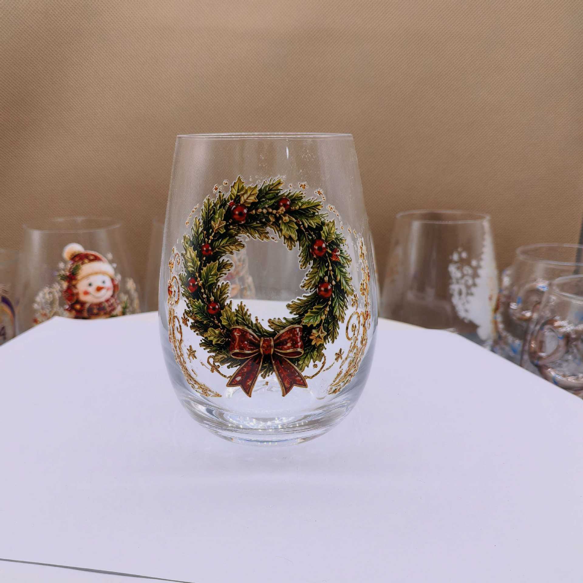 Clear borosilicate Christmas glass cup with a raised painted flat wreath holiday motif