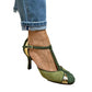 Green suede T strap stiletto heels with a gold buckle worn by a woman, product photo