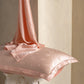 Birds And Flowers Pink jacquard silk pillowcase in pink with silk draped over it, single option