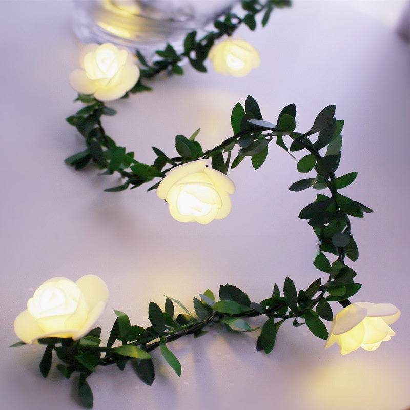 Warm White flower LED fairy string light on a green leaf vine with a warm glow, decorative photo